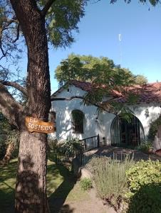 ein Schild auf einem Baum vor einem Haus in der Unterkunft Monoambiente El Sosiego in Alta Gracia + 3 Fotos