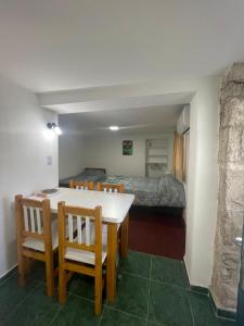una habitación con mesa y sillas y un dormitorio en Monoambiente El Sosiego en Alta Gracia
