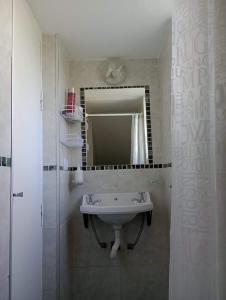 y baño con lavabo y espejo. en Monoambiente El Sosiego en Alta Gracia