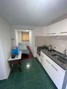 eine Küche mit Spüle und Tisch in einem Zimmer in der Unterkunft Monoambiente El Sosiego in Alta Gracia