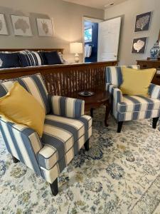 a living room with two chairs and a bed at River House Inn in Snow Hill