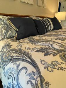 a bed with a blue and white blanket and pillows at River House Inn in Snow Hill