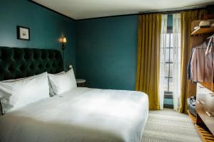 a bedroom with a large white bed and a window at Hotel Emeline in Charleston