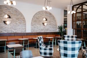 a restaurant with arched windows and tables and chairs at Emeline in Charleston