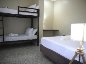 a bedroom with two bunk beds and a lamp at Casita A in Pagudpud