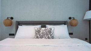 a bed with two pillows and two lamps on it at S-Cape Hotel Fethiye in Fethiye