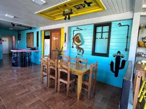comedor con mesa y pared azul en Vila do Chaves - Nossa hospedagem foi matéria no G1, en Garopaba