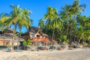 - un complexe sur la plage avec des chaises et des palmiers dans l'établissement Yoma Cherry Lodge, à Ngapali Beach