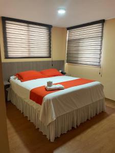 1 cama grande en un dormitorio con 2 ventanas en Terraza Dreams, en Quito