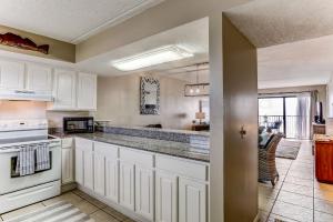 a kitchen with white cabinets and a stove top oven at Amelia The Sea - 558 ASea in Fernandina Beach