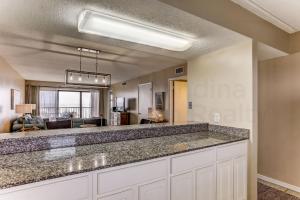 a kitchen with a counter top and a living room at Amelia The Sea - 558 ASea in Fernandina Beach