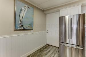 eine Küche mit einem Kühlschrank und ein Wandgemälde in der Unterkunft Oceanview Upper Unit Condo in Amelia Island