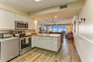 a kitchen with white cabinets and a dining room at Oceanview Upper Unit Condo in Amelia Island