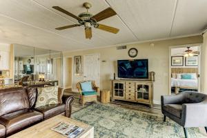 a living room with a ceiling fan and a tv at Oceanview Upper Unit Condo in Amelia Island