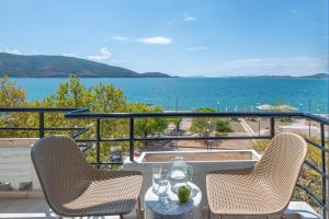 a table and chairs on a balcony with the ocean at El Greco in Igoumenitsa
