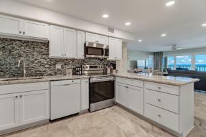 a kitchen with white cabinets and a microwave at Oceanfront w Beach Access in Amelia Island