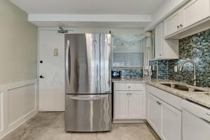 a stainless steel refrigerator in a kitchen with white cabinets at Oceanfront w Beach Access in Amelia Island