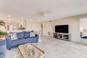 a living room with a blue couch and a tv at Oceanfront w Beach Access in Amelia Island