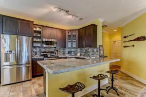 a large kitchen with wooden cabinets and stainless steel appliances at Ocean Place Beach Condo in Fernandina Beach