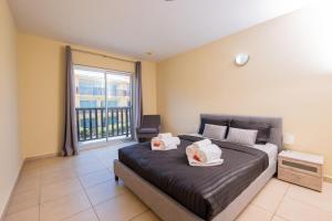 una camera da letto con un letto e una grande finestra di Droom appartement met uitzicht op de jachthaven a Jan Thiel