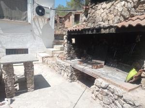 un edificio de piedra con un banco de piedra y una mesa en Casa Calafell, en Segur de Calafell