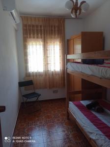 1 Schlafzimmer mit 2 Etagenbetten und einem Fenster in der Unterkunft Casa Calafell in Segur de Calafell