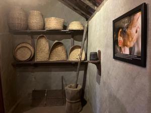 a shelf with baskets and a picture on a wall at Zyamadhari in Mananthavady