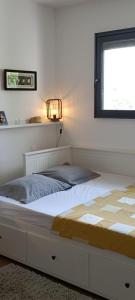 Bett in einem Schlafzimmer mit Fenster in der Unterkunft Chambre chaleureuse avec une vue dégagée in La Frette-sur-Seine