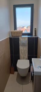 La salle de bains est pourvue de toilettes et d'une fenêtre. dans l'établissement Chambre chaleureuse avec une vue dégagée, à La Frette-sur-Seine