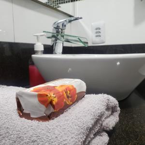 uma casa de banho com um lavatório e uma toalha em Hospedagem Costa BNU - Q2 em Blumenau