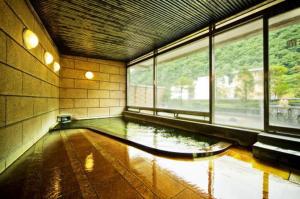 a room with a pool of water in a room with windows at 旬樹庵　菊水 in Chikuma