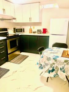 uma cozinha com uma mesa e um frigorífico branco em CozyHome em Markham