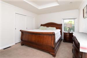 1 dormitorio con cama de madera y ventana en 3BR Home Near Stanford Great Back Yard King Bed, en Menlo Park