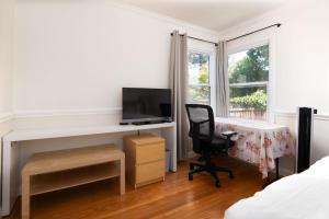 1 dormitorio con escritorio, silla y TV en 3BR Home Near Stanford Great Back Yard King Bed, en Menlo Park