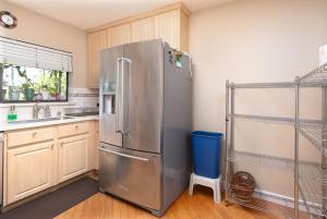 un frigorifero in acciaio inossidabile in una cucina con mobili in legno di 3BR Home Near Stanford Great Back Yard King Bed a Menlo Park