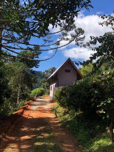 un chemin de terre avec un bâtiment sur le côté dans l'établissement Chalé Campestre, à Gonçalves