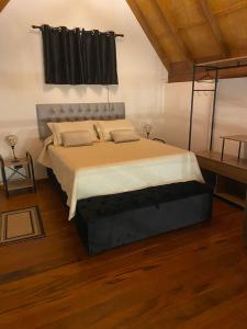 - une chambre dotée d'un grand lit avec un cadre noir dans l'établissement Chalé Campestre, à Gonçalves
