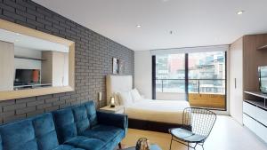 een woonkamer met een blauwe bank en een slaapkamer bij 406 Heights Loft in Bogota