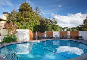 una piscina en un patio con sillas y árboles en Hotel Abrego, en Monterey