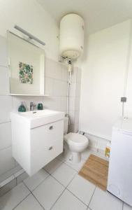 a white bathroom with a toilet and a sink at KayChouchou- Appart cosy au cœur de Fort-de-France in Fort-de-France