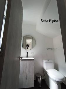 a bathroom with a toilet and a sink and a mirror at Ricaurte, Cundinamarca in Girardot