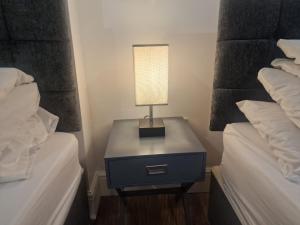 a table with a lamp on it next to two beds at Furnished 1 bedroom apartment in Bristol