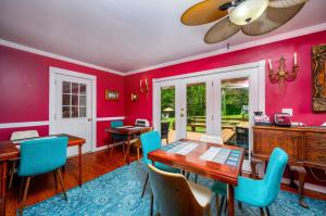 a dining room with red walls and a table and chairs at Mountain Treasure Bed and Breakfast in Maplecrest