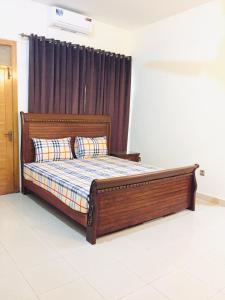 a bed in a bedroom with a wooden bed frame at Islamabad Residency 2 in Islamabad