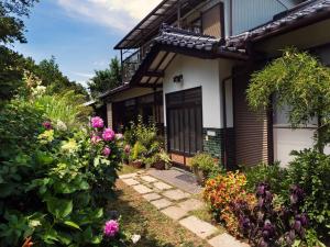 un jardin avec des fleurs en face d'une maison dans l'établissement Asama Vista quiet home with view, Foreign Hosts, à Miyota