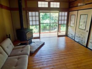 a living room with a couch and a stove at Asama Vista quiet home with view, Foreign Hosts in Miyota
