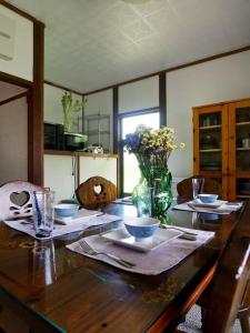 御代田町的住宿－Asama Vista quiet home with view, Foreign Hosts，木桌,放着碗和花瓶