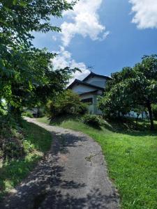 Asama Vista quiet home with view, Foreign Hosts في Miyota: طريق ترابي يؤدي إلى منزل على تلة