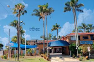 un hotel con palmeras frente a un edificio en Sapphire Palms Motel, en The Entrance