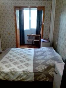 1 dormitorio con cama, ventana y mesa en markaz 6 Uy-122A Honadon-9, en Tashkent